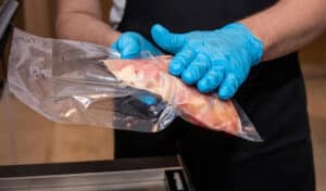 homem pega em embalagens em vácuo